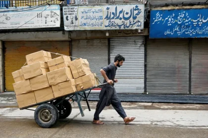 یک کارگر پاکستانی در حال کشیدن چرخ دستی