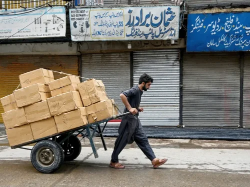 یک کارگر پاکستانی در حال کشیدن چرخ دستی